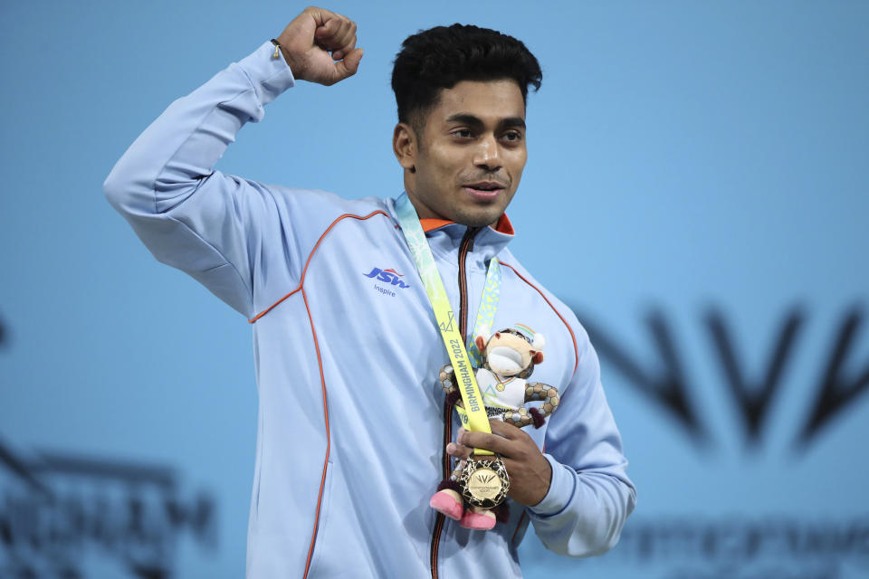 India's Achinta Sheuli, center, celebrates with his gold medal as he stands on the podium following the Men's weightlifting 79kg Final at The NEC on day three of the Commonwealth Games in Birmingham, Sunday July 31, 2022. (Isaac Parkin/PA via AP)