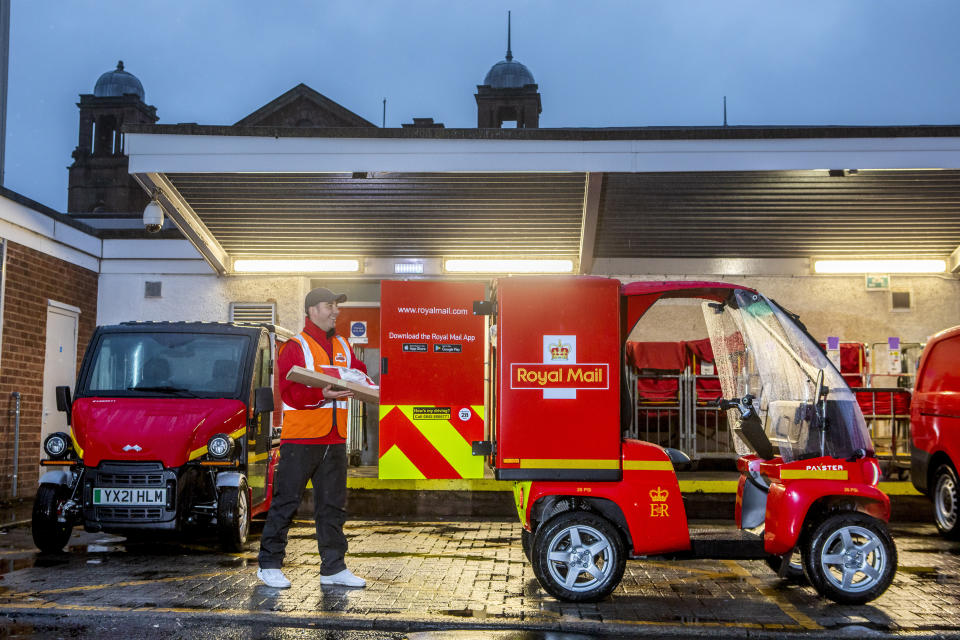 A Royal Mail worker loads one of the micro electric vehicles at Scotland’s first all-electric delivery office, in Govan, Glasgow (Royal Mail/PA)