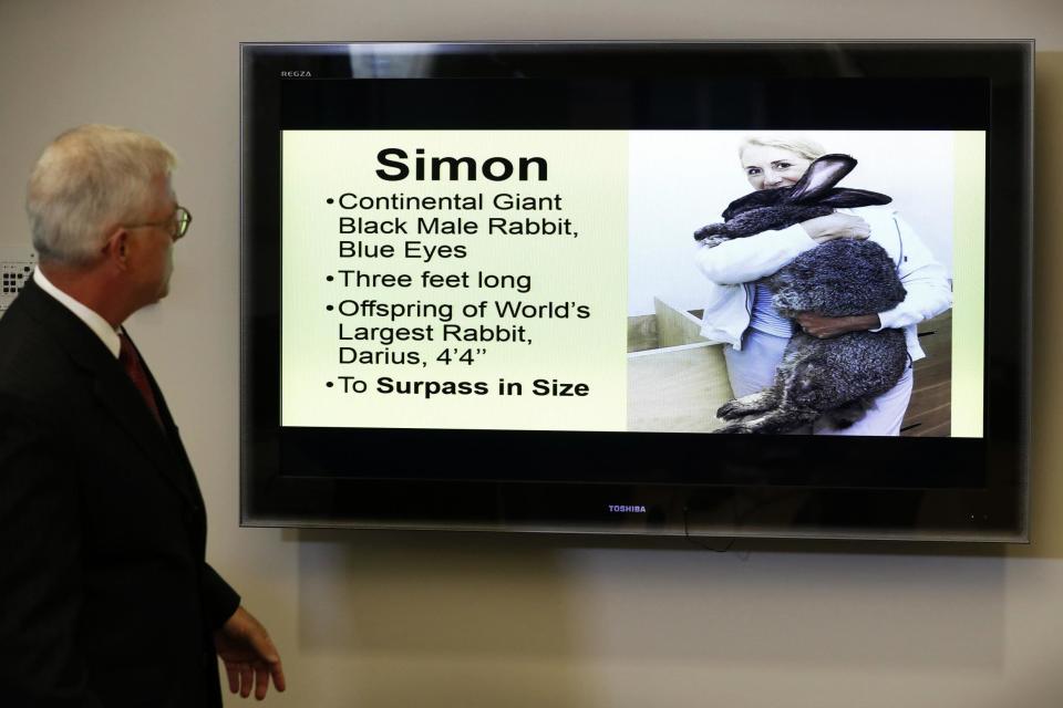 Attorney Guy Cook speaks a news conference while looking at a photo of Simon: AP