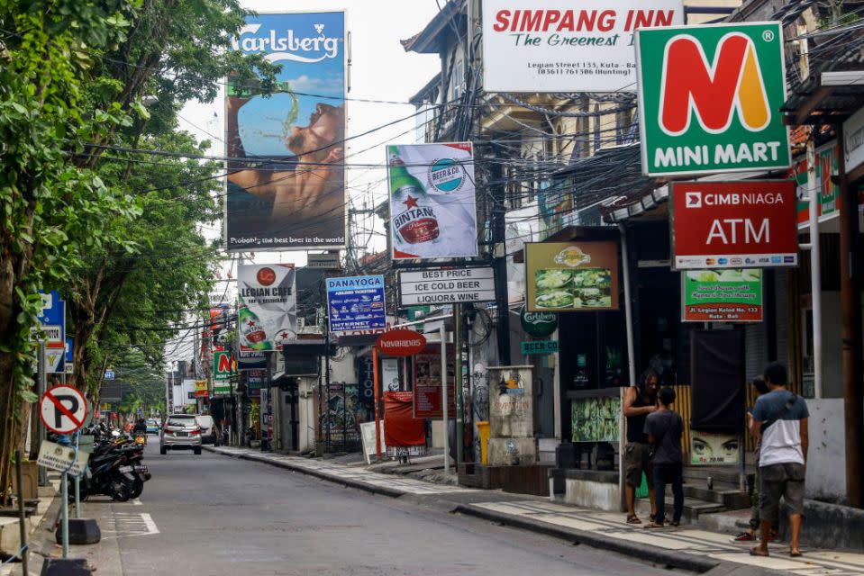  A number of residents are in front of a closed bar in Kuta Bali.