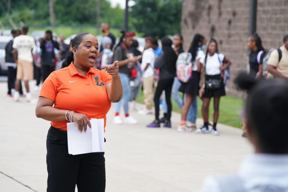 Lincoln Middle School assistant principal Anjanette White points students to help desks on the first day of school Aug. 14, 2023. Lincoln held a host of community partners, who gave out school supplies, treats and encouragement to new and returning students.