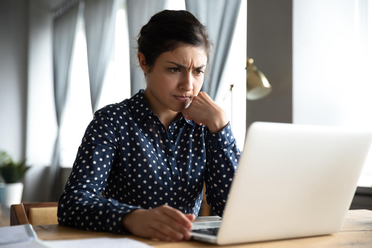 Concerned puzzled young indian woman student professional use look at laptop at home office feel stressed frustrated about computer software problem worried of technology negative online news concept