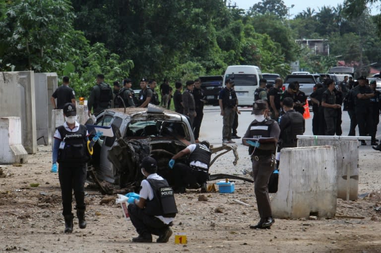 A Thai forensic unit inspects the scene of a roadside bomb which killed four army rangers in the restive Southern Thai province of Pattani on September 22, 2017