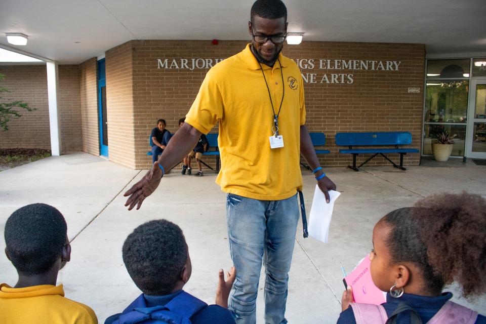 Chauncey Walker, founder of Develop A Dream and a Physical Hducation teacher at Marjorie Rawlings Elementary, shakes the hand of a student at the school during the father cheering event organized by the Fatherhood Initiative of Gainesville For All in Gainesville on May 5, 2022. Walker worked with GNV4all with Jacob Lawrence to help coordinate the event to help encourage students and bring positive role models to support them. (Lawren Simmons/Special to the Sun)