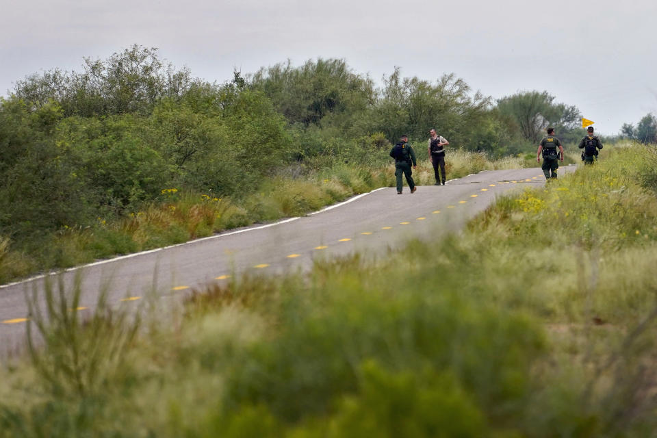 U.S. Border Patrol agents and an Arizona Fish and Game Officer search for a group of migrants evading capture along a road at the base of the Baboquivari Mountains, Thursday, Sept. 8, 2022, near Sasabe, Ariz. The desert region located in the Tucson sector just north of Mexico is one of the deadliest stretches along the international border with rugged desert mountains, uneven topography, washes and triple-digit temperatures in the summer months. Border Patrol agents performed 3,000 rescues in the sector in the past 12 months. (AP Photo/Matt York)