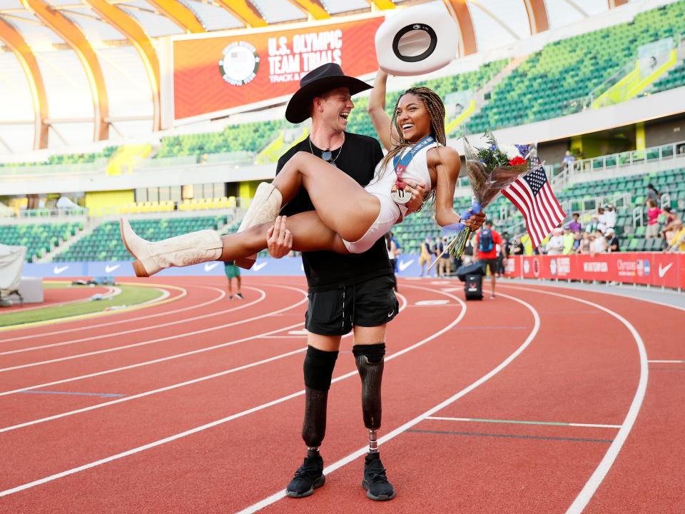Hunter Woodhall holds Tara Davis in his arms as they celebrate her qualifying for the Tokyo Olympics.