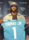 Jacksonville Jaguars first-round draft pick wide receiver Brian Thomas Jr. poses while holding a jersey during an NFL football press conference, Friday, April 26, 2024, in Jacksonville, Fla. (AP Photo/Gary McCullough)