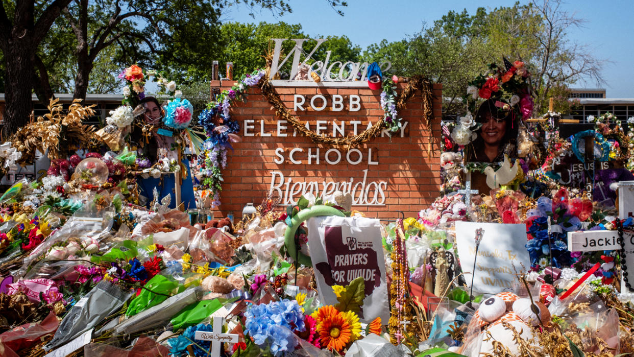 The Robb Elementary School sign strewn with flowers and gifts.