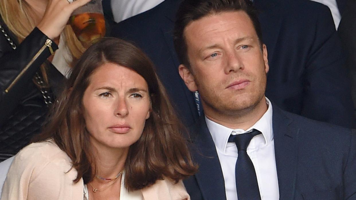 Jamie Oliver in a suit with Jools Oliver in a white dress