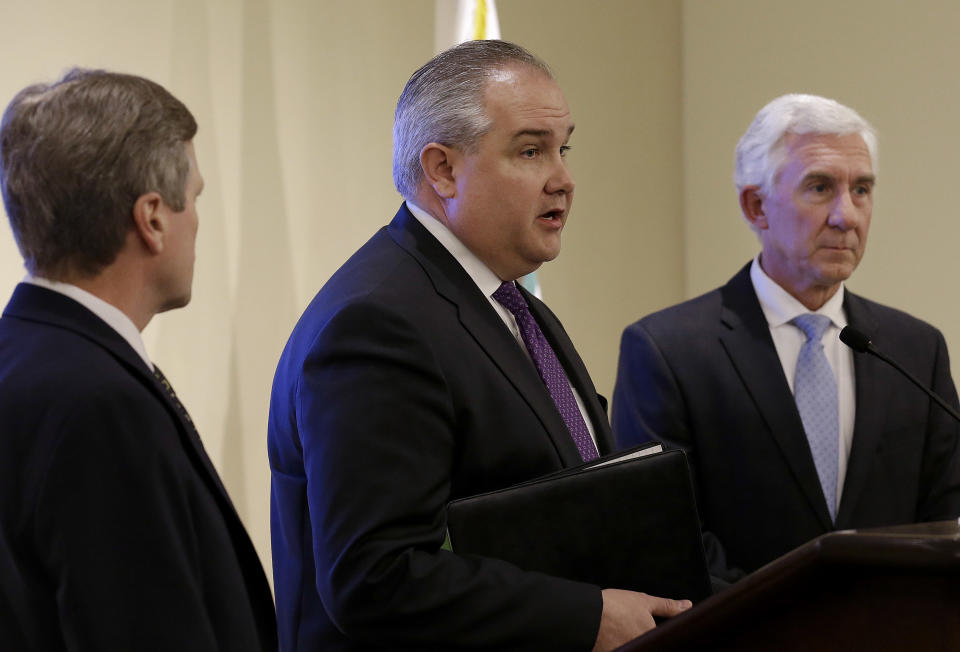 Keith Stephens, senior director of business lines and field operations communications for Pacific Gas & Electric Co., center, as James Fama, left, vice president of energy delivery for Edison Electric Institute and Gregg Lemler, vice president of transmission operations for PG&E at a news conference listen in San Francisco, Thursday, April 10, 2014. PG&E offered a $250,000 reward on Thursday for information leading to an arrest and conviction in an attack nearly a year ago on phone lines and the power grid in Silicon Valley. (AP Photo/Jeff Chiu)