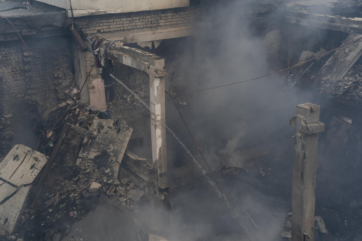 A Ukrainian firefighter works inside a destroyed cultural center in Derhachi, eastern Ukraine, Sunday, May 15, 2022. A Russian airstrike destroyed the venue on May 12. (AP Photo/Bernat Armangue)