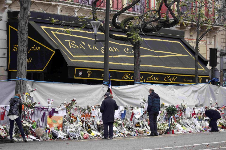 People mourn in front of the screened-off facade of the Bataclan Cafe adjoining the concert hall, one of the sites of the deadly attacks in Paris, France, November 26, 2015 a day before a ceremony to pay tribute to the 130 victims. (REUTERS/Charles Platiau)