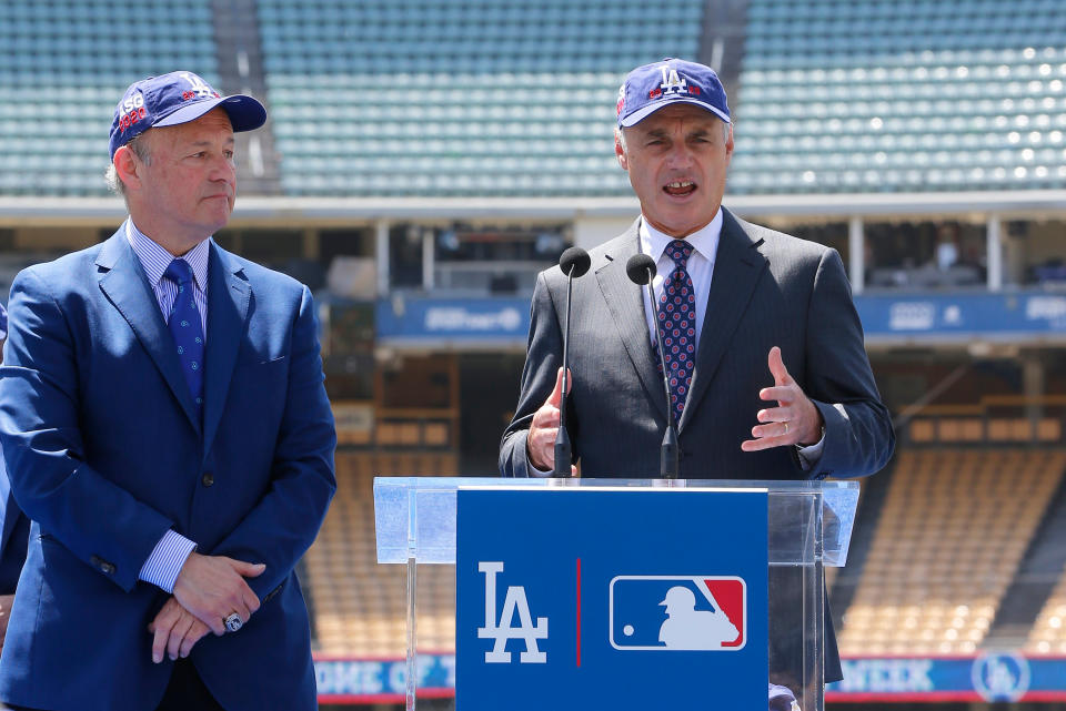 FILE - In this April 11, 2018, file photo, Los Angeles President and CEO Stan Kasten, left, and Baseball Commissioner Rob Manfred announce that Dodger Stadium will host the All-Star Game in 2020 for the first time since 1980 at a news conference in Los Angeles. Dodger Stadium’s 40-year wait to host the All-Star Game is going to last even longer. The game scheduled for July 14 was canceled Friday, July 3, 2020, because of the coronavirus pandemic, and Dodger Stadium was awarded the 2022 Midsummer Classic. (AP Photo/Damian Dovarganes, File)