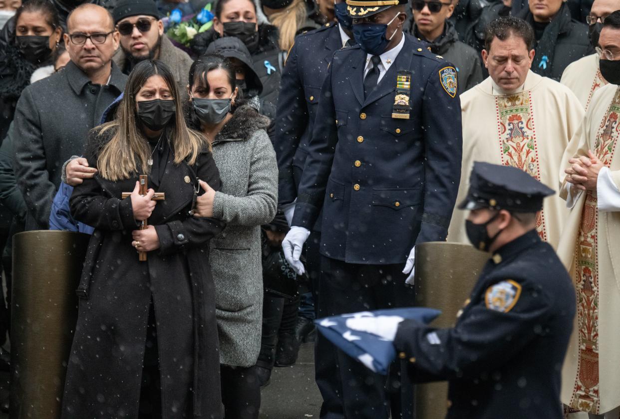 NYPD officer Jason Rivera's widow, Dominique Luzuriaga, clutches a crucifix after Rivera's funeral Friday at St. Patrick's Cathedral in Manhattan, New York.