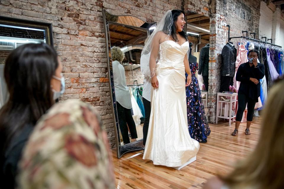 Marisol De La O, center, a paramedic from Nashville, exclaims at a dress she tries on with her friends to help her decide at Wedding Belles in Clarksville, Tenn., on Tuesday, Aug. 11, 2020.