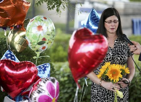 A woman speaks with a journalist as she is overcome with emotions near a memorial outside of the offices for WDBJ7 in Roanoke, Virginia, August 26, 2015. REUTERS/Chris Keane