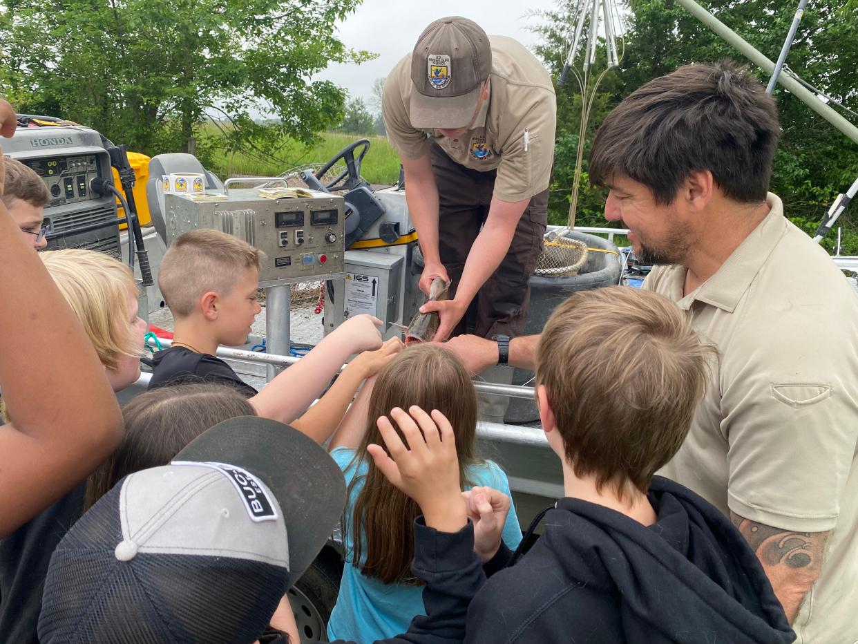 Austin McBee and Pablo Oleiro, technicians with the U.S. Fish and Wildlife Service on Wednesday allowed Two Mile Prairie Elementary School students a close-up examination of native and invasive fish.