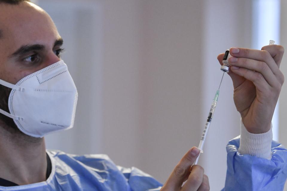 A nurse prepares a vaccine prior to the vaccination of elderly people at a nursing house in Athens, Monday, Jan. 4, 2021. Vaccinations were expanded from 9 to 50 hospitals nationwide on Monday. (Louisa Gouliamaki/Pool via AP)