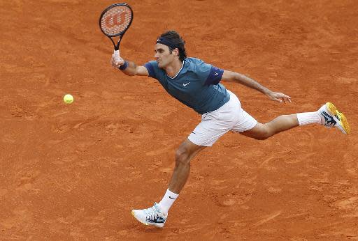 El tenista suizo Roger Federer devuelve la pelota ante su compatriota Stanislas Wawrinka, en la final del Torneo de Montecarlo, el 20 de abril de 2014 en Mónaco (AFP | VALERY HACHE)