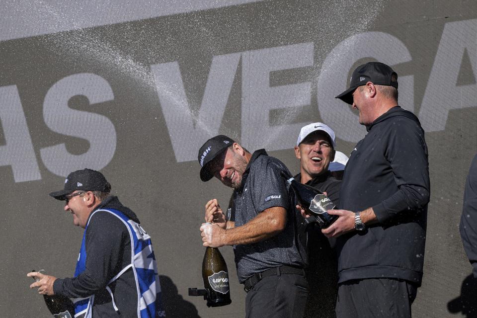 First-place team champions captain Brooks Koepka, of Smash GC, Jason Kokrak, Graeme McDowell, Talor Gooch and their caddies celebrate onstage after the final round of LIV Golf Las Vegas at Las Vegas Country Club, Saturday, Feb. 10, 2024, in Las Vegas. (Montana Pritchard/LIV Golf via AP)