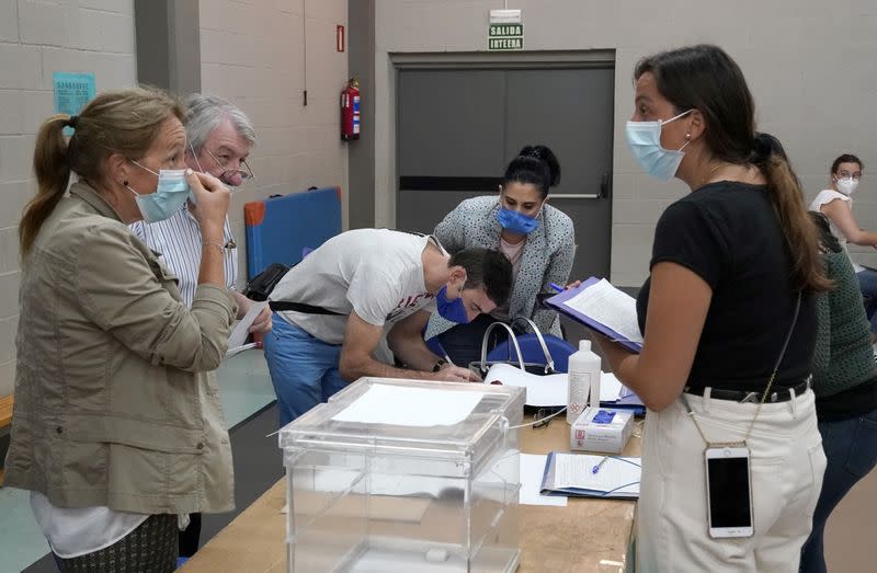 Workers organize papers at a polling station before the start of the voting during the Basque regional elections, amid the coronavirus disease (COVID-19) outbreak, in Durango