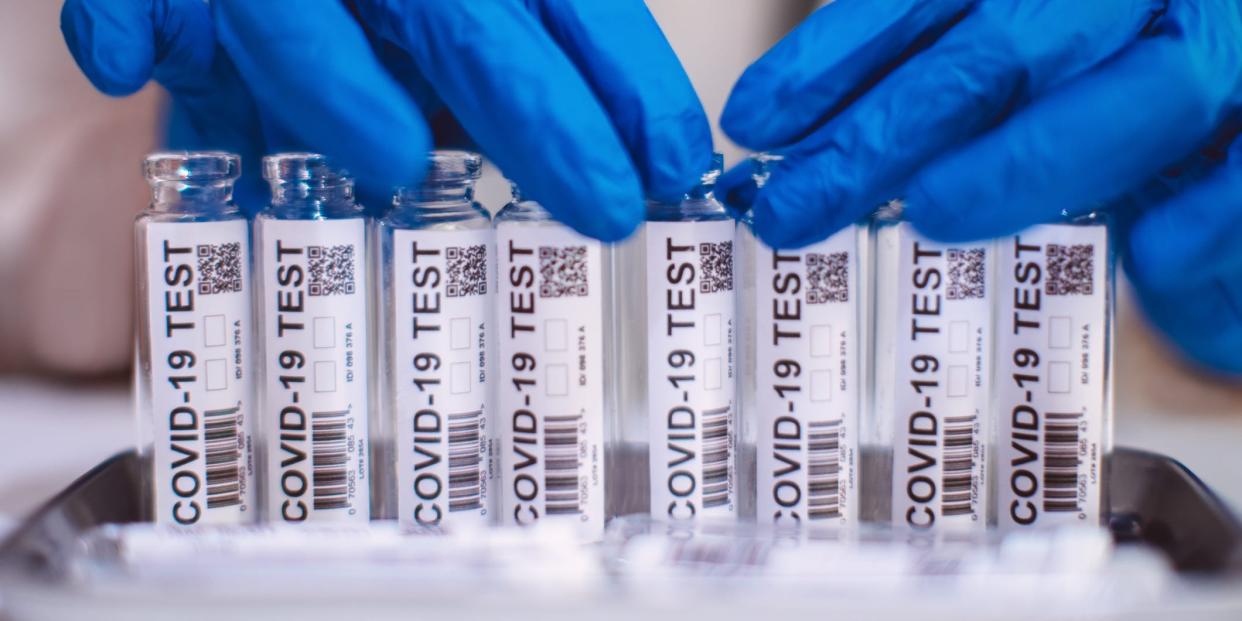 Doctor in protection gloves examining & organising test kit for COVID-19 in laboratory (file photo).