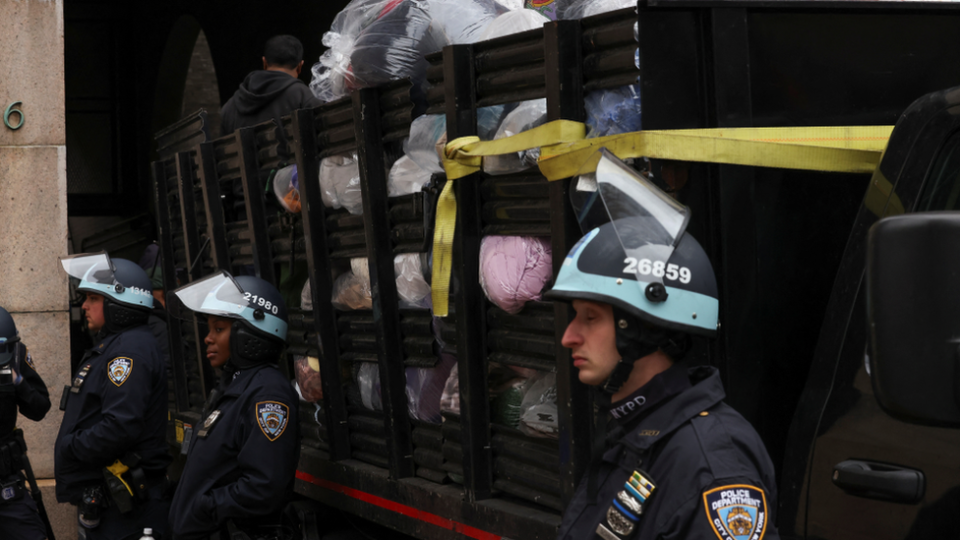 Police stand guard next to a lorry with confiscated camping equipment