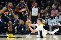 Orlando Magic forward Franz Wagner, right, passes the ball to a teammate as Phoenix Suns forward Mikal Bridges (25) and center Deandre Ayton (22) watch during the first half of an NBA basketball game Saturday, Feb. 12, 2022, in Phoenix. (AP Photo/Ross D. Franklin)