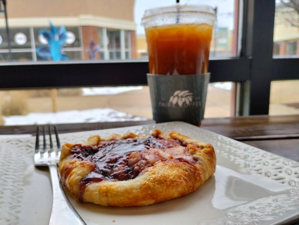A blackberry cream cheese Galette is pictured next to a cold brew at Faire Coffee. The cafe's Peoria location closed in February 2023.
