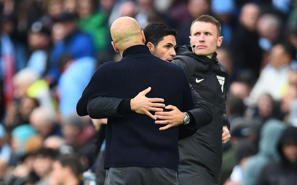 Arsenal manager Mikel Arteta (C-R) and Manchester City's manager Pep Guardiola (C-L) hug after the English Premier League match between Manchester City and Arsenal in Manchester, Britain, 31 March 2024