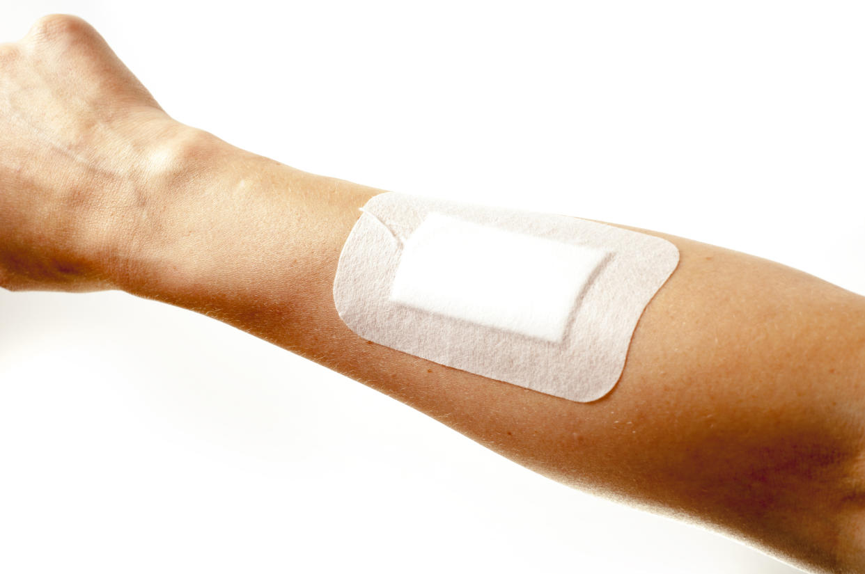 adhesive bandages on injury hand on white background