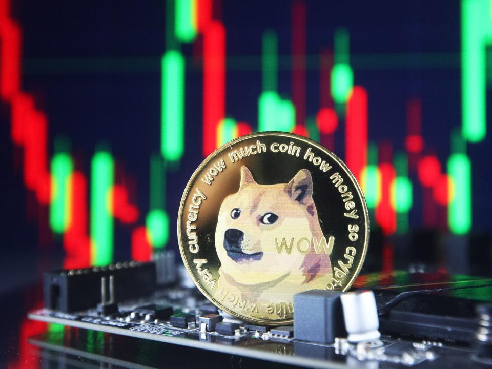 Dogecoin cryptocurrency coin and a graph are pictured in Kyiv on 08 July, 2021.