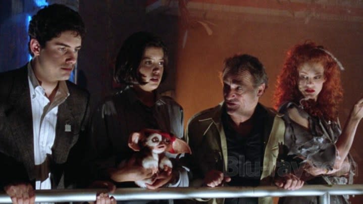 Four people and Gizmo look forward in Gremlins 2: The New Batch.