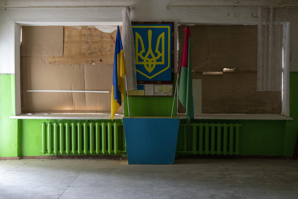 Windows, broken by an explosion and protected with cardboard and wood, are photographed in a school reception at Mykhailo-Kotsyubynske's lyceum, which was bombed by Russian forces on the 4th of March, in Chernihiv, Ukraine, Tuesday, Aug. 30, 2022. (AP Photo/Emilio Morenatti)