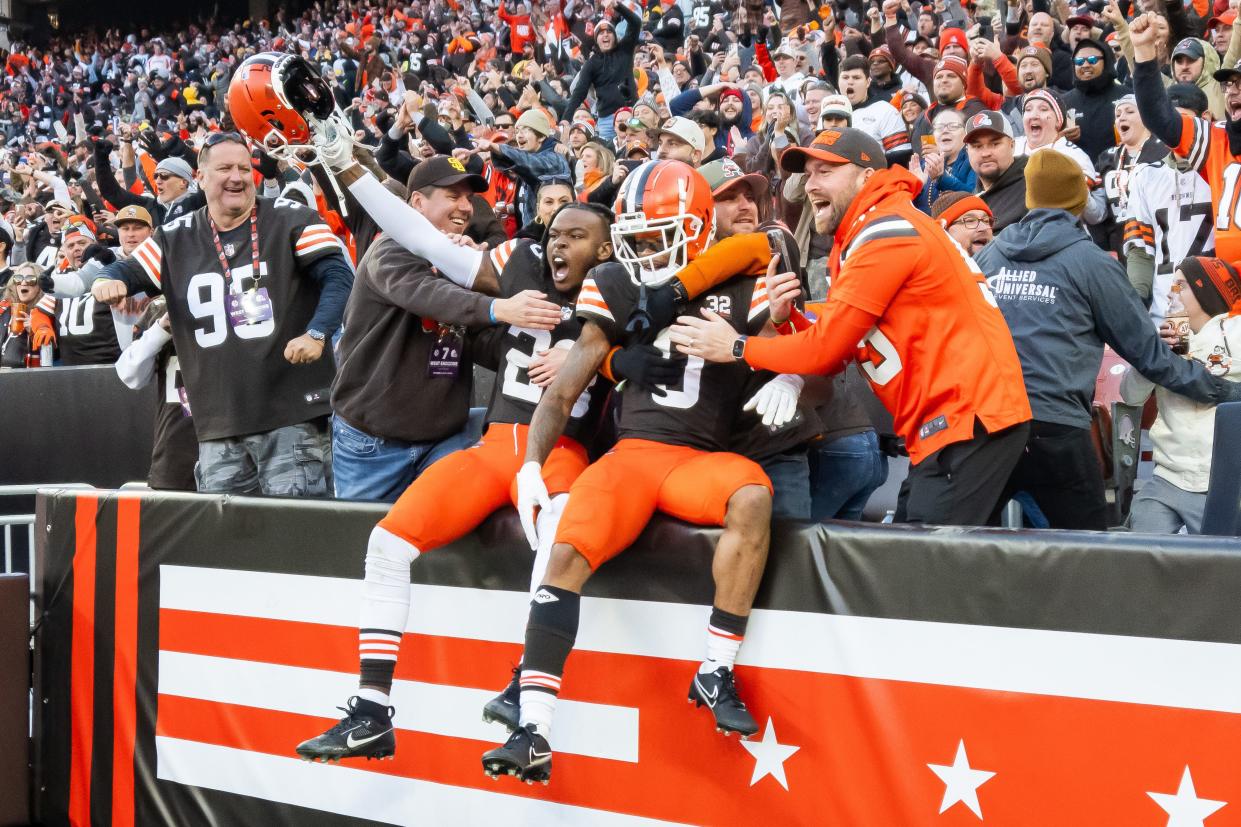 Browns cornerbacks Martin Emerson Jr. (23) and Greg Newsome II (0) celebrate with fans after a win over the Pittsburgh Steelers at Cleveland Browns Stadium, Nov. 19, 2023.