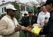 FILE - Lee Elder signs autographs for patrons outside the club house at the 2008 Masters golf tournament at the Augusta National Golf Club in Augusta, Ga., Monday, April 7, 2008. Elder broke down racial barriers as the first Black golfer to play in the Masters and paved the way for Tiger Woods and others to follow. The PGA Tour confirmed Elder’s death, which was first reported by Debert Cook of African American Golfers Digest. No cause or details were immediately available, but the tour said it spoke with Elder's family. He was 87. (AP Photo/Elise Amendola, File)