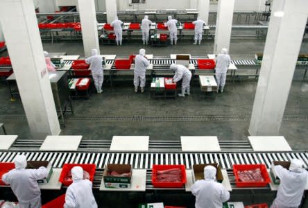 FILE PHOTO: Employees sort cuts of fresh pork inside a Shuanghui factory in Zhengzhou, Henan province, China March 15, 2013. REUTERS/Stringer