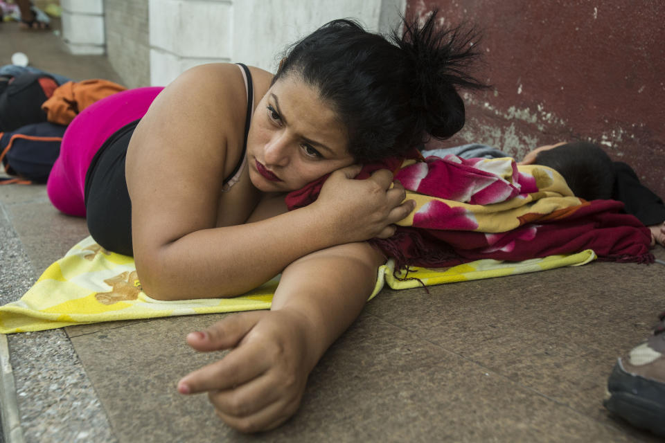 A migrant from El Salvador waits in the street next to the Mexican Commission for Migrant Assistance office waiting for her turn to get the documents needed that allows them to stay in Mexico, in Tapachula, early Thursday, June 20, 2019. The flow of migrants into southern Mexico has seemed to slow in recent days as more soldiers, marines, federal police, many as part of Mexico's newly formed National Guard, deploy to the border under a tougher new policy adopted at a time of increased pressure from the Trump administration. (AP Photo/Oliver de Ros)