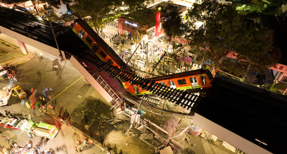 A general view of damage caused after a railway overpass and train collapsed onto a busy road.