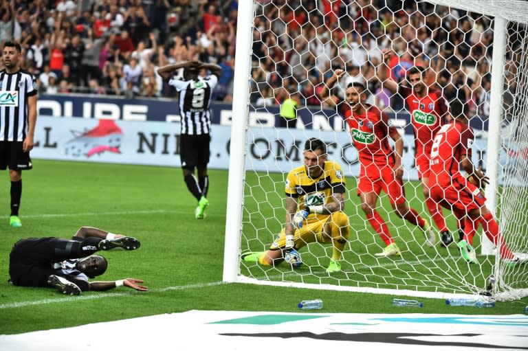 Angers' Issa Cissokho (L) falls as Angers' goalkeeper Alexandre Letellier (C) and Paris Saint-Germain's players react after he scored an own goal during the French Cup final football match