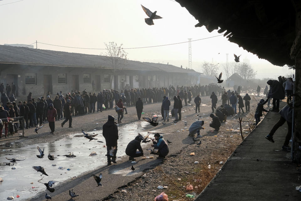 Migrants stand in a food line in Belgrade, Serbia