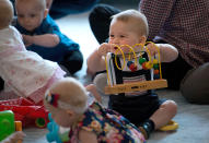 Britain's Prince George, center, plays during a visit to Plunket nurse and parents group at Government House in Wellington, New Zealand, Wednesday, April 9, 2014. Plunket is a national not-for-profit organization that provides care for children and families in New Zealand. Britain's Prince William, his wife Kate, the Duchess of Cambridge and their son, Prince George, are on a three-week tour of New Zealand and Australia. (AP Photo/Marty Melville, Pool)