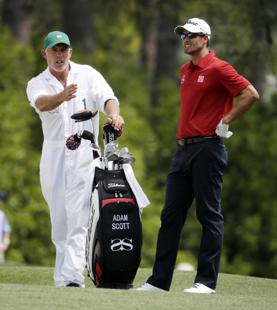 Caddie Steve Williams gives directions to Adam Scott, of Australia, on the first fairway during the second round of the Masters golf tournament Friday, April 11, 2014, in Augusta, Ga. (AP Photo/Darron Cummings)