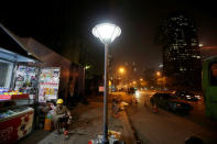 A worker rests outside a construction site at night in Beijing's central business district area, China April 16, 2017. REUTERS/Jason Lee