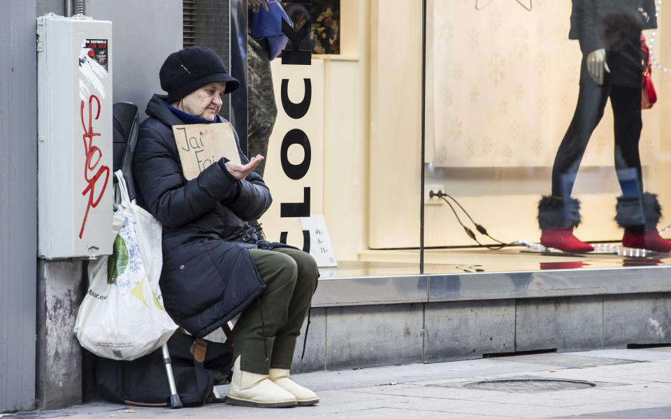 A woman asks for money on a shopping street in Brussels on Thursday, Nov. 22, 2012. With national budgets being slashed and unemployment in the 27-nation EU at 11.6 percent, some EU leaders are arguing that it’s time for the European Union to take some of its own medicine and cut its planned spending for the years 2014-2020. (AP Photo/Geert Vanden Wijngaert)