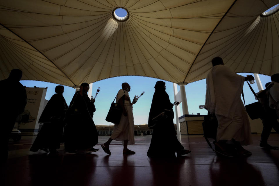 Pilgrims walk under giant umbrellas at the Hajj terminal of King Abdulaziz International Airport in Jeddah, Saudi Arabia, Tuesday, June 20, 2023. Saudi Arabia has ambitious plans to welcome millions more pilgrims to Islam's holiest sites. But as climate change heats an already scorching region, the annual Hajj pilgrimage could prove even more daunting. (AP Photo/Amr Nabil)