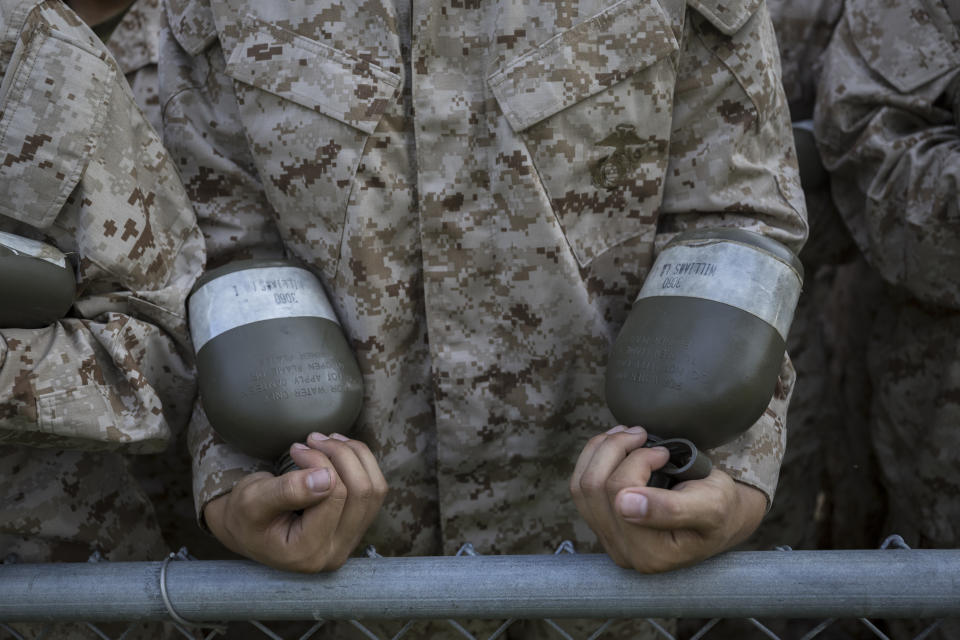 A U.S. Marine Corps recruit holds two canteens of water during a training exercise at the Marine Corps Recruit Depot, Wednesday, June 28, 2023, in Parris Island, S.C. (AP Photo/Stephen B. Morton)