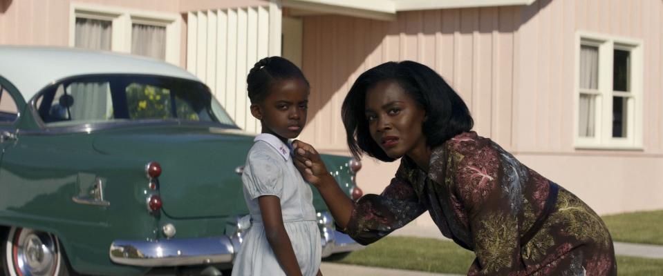 An African-American family looks at their neighbors with concern.