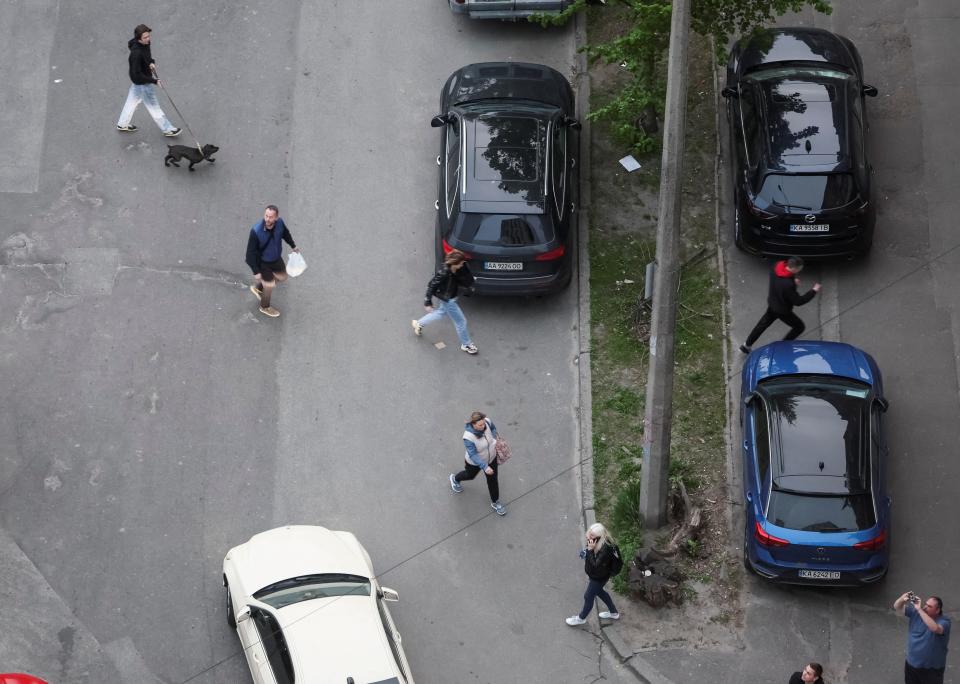 People run as a drone flies in the sky over the city amid Russia's attack on Ukraine, in Kyiv, Ukraine May 4, 2023.