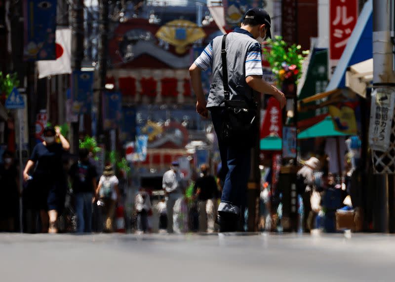 Passersby are seen through a heat haze during hot weather at Sugamo district in Tokyo